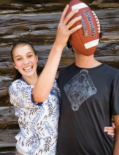 dziewczyna trzyma piłkę nożną przed twarzą faceta