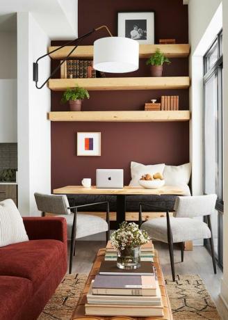 czerwone ściany, kącik śniadaniowy, drewniany stół, kremowe krzesła, pomarańczowa kanapa zaprojektowana przez byrona risdona