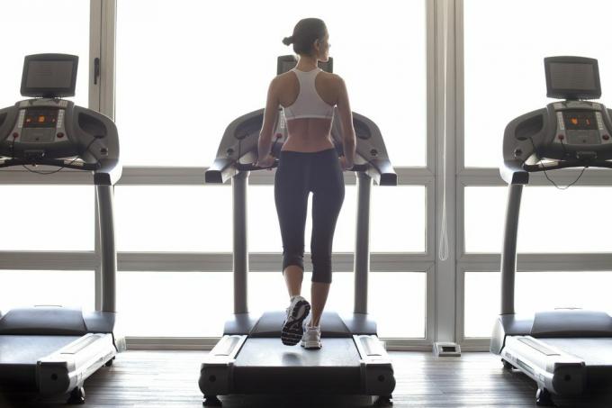 Frau, die im Fitnessstudio auf dem Laufband joggt