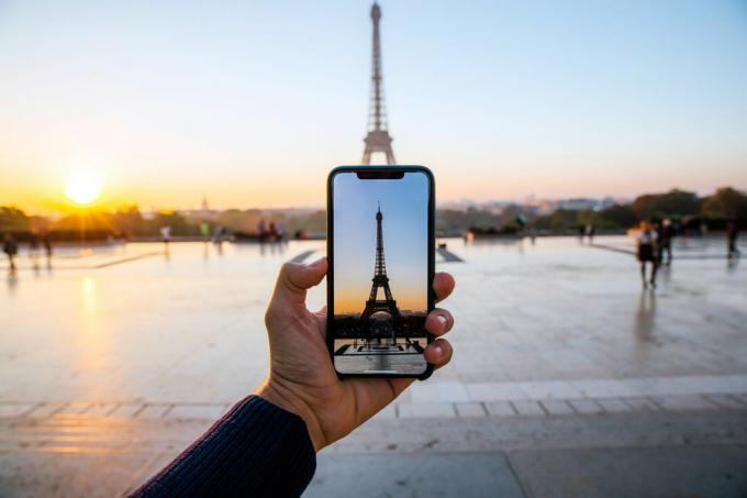 سائح يأخذ صورة لبرج إيفل بهواتف ذكية ومنظور شخصي ، باريس ، فرنسا