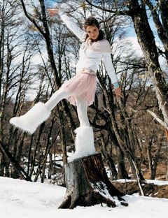 ragazza in piedi sul ceppo d'albero nella neve