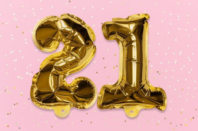številka balona iz zlate folije, številka enaindvajset na roza podlagi z bleščicami
