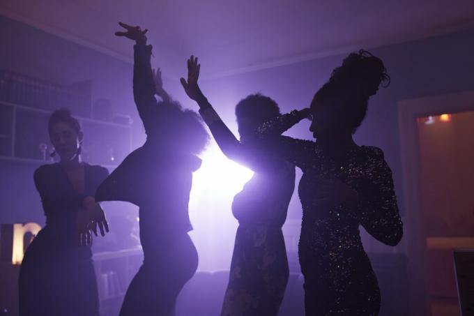 молодые женщины танцуют и аплодируют на домашней вечеринке
